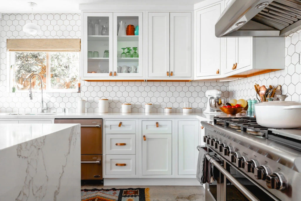 Bright remodeled kitchen with white cabinets and a large range