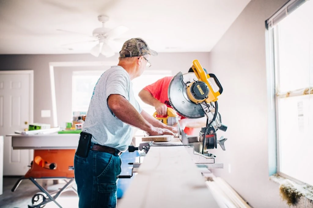 Carpenter cutting lumber with a miter saw