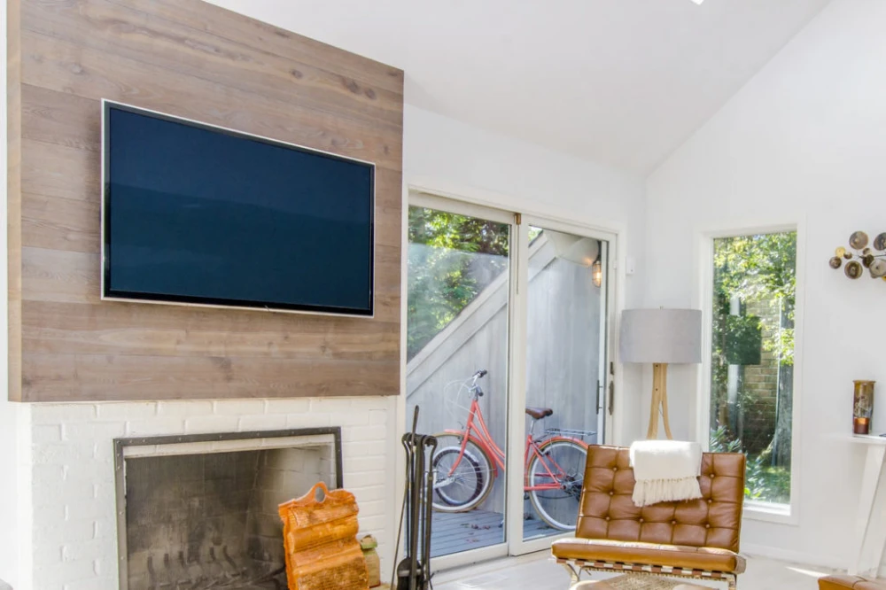 Wall-mounted television above a modern fireplace