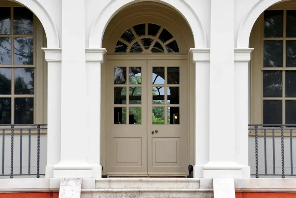 Updated front entry door framed by white columns