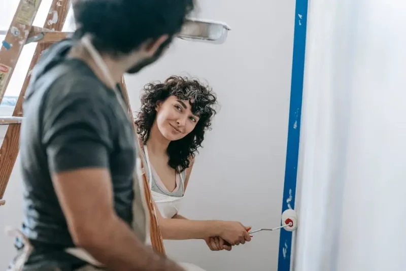 Homeowner and contractor using a level during a wall project