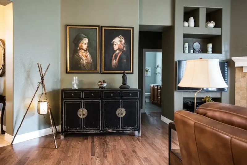 Framed artwork displayed above a cabinet in a living room