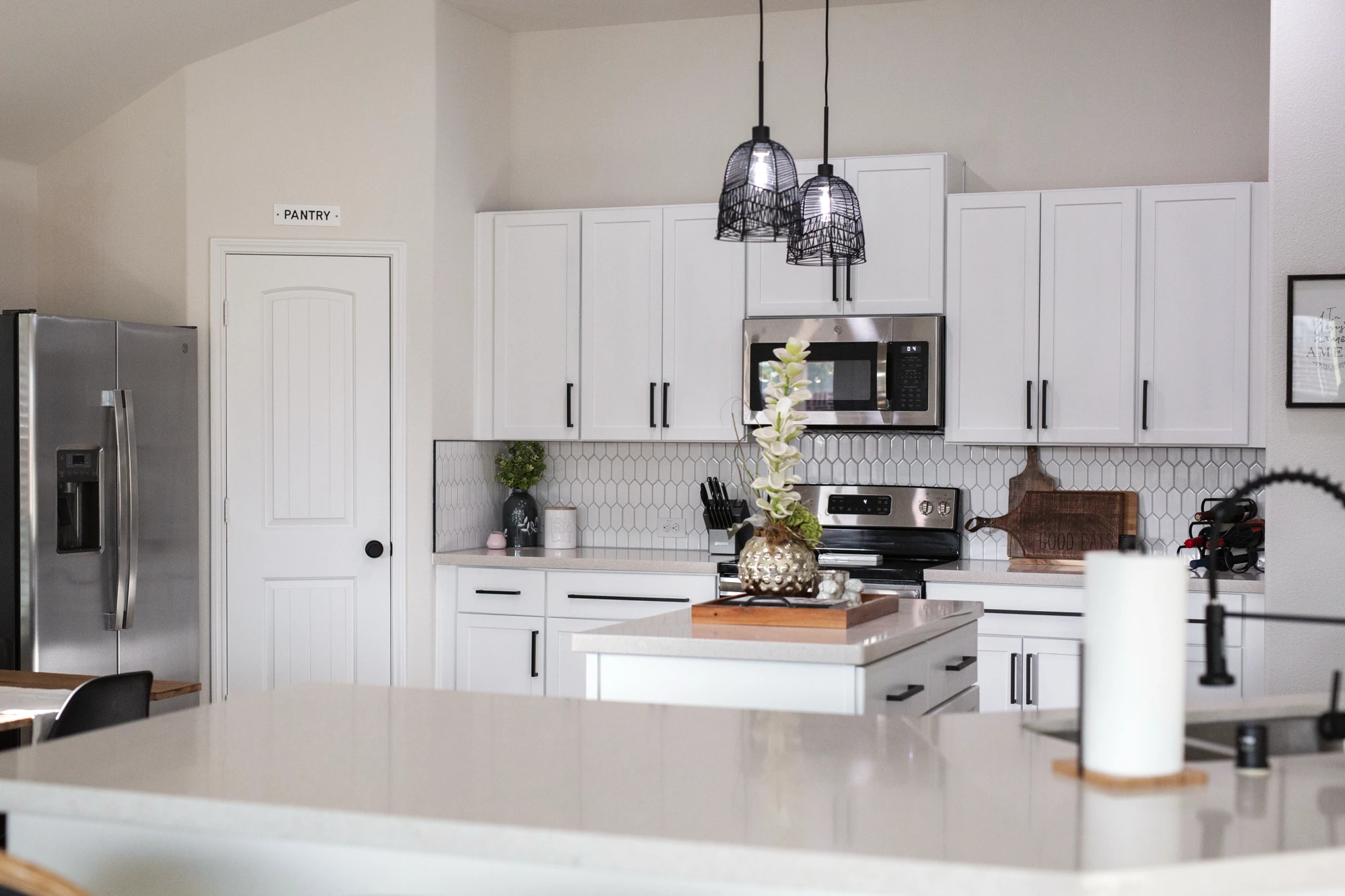 Wide kitchen view across a white quartz island