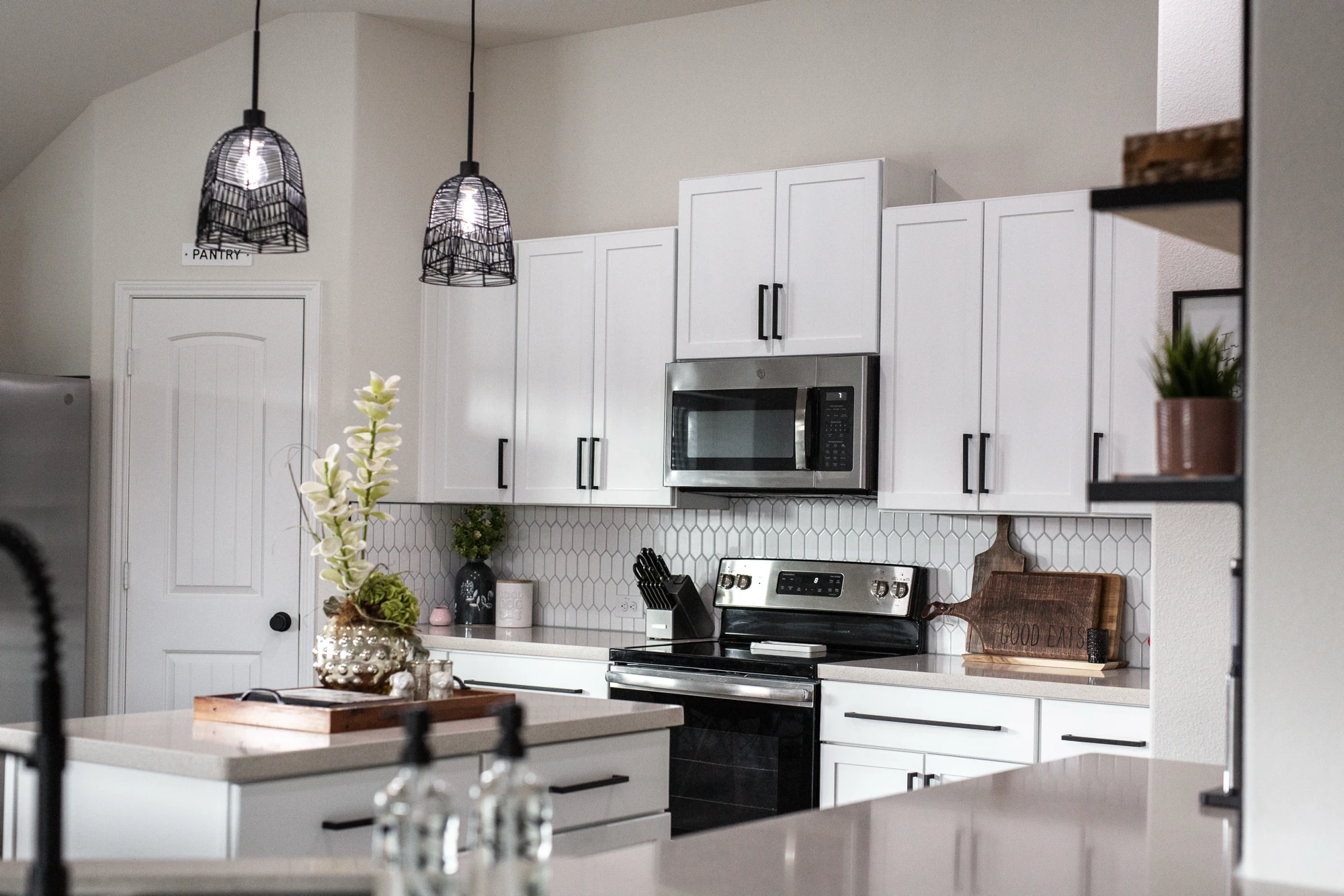 Bright white kitchen with an island and stainless range