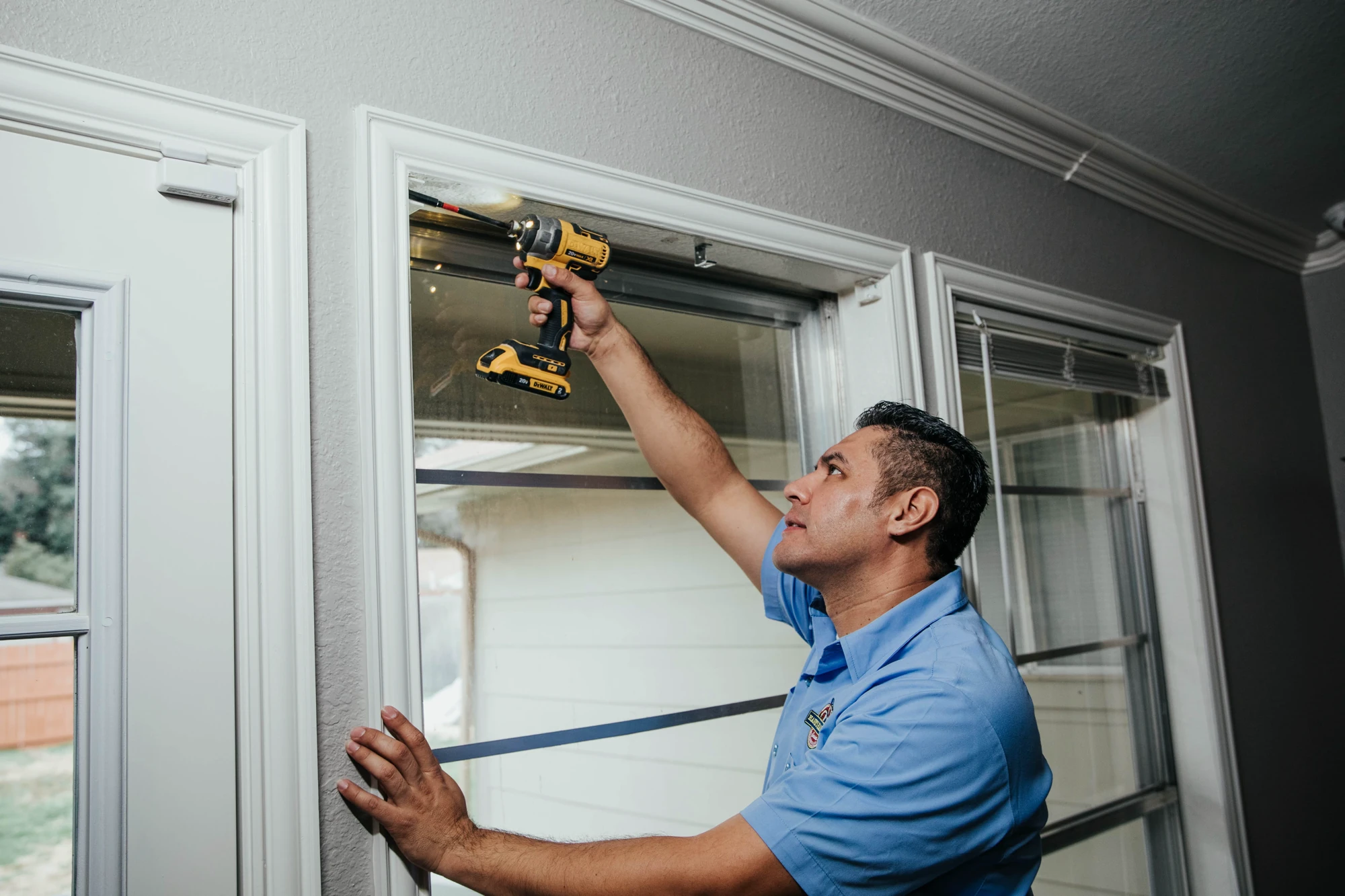 Hank's technician installing hardware above an interior window
