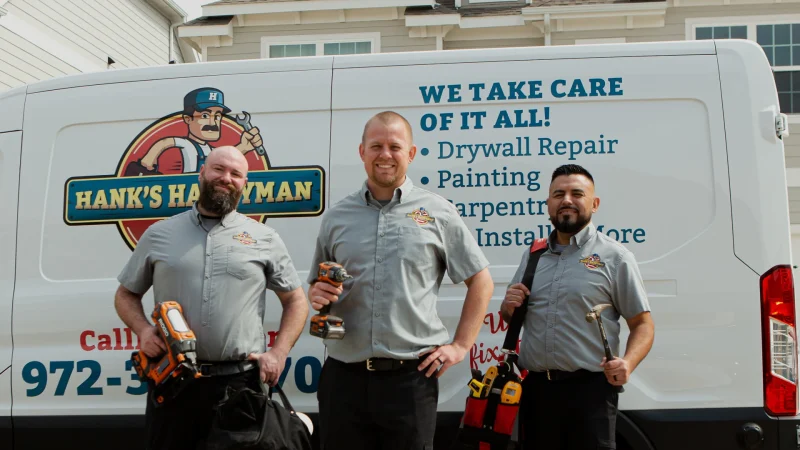 Hank's Handyman team standing in front of a branded service van