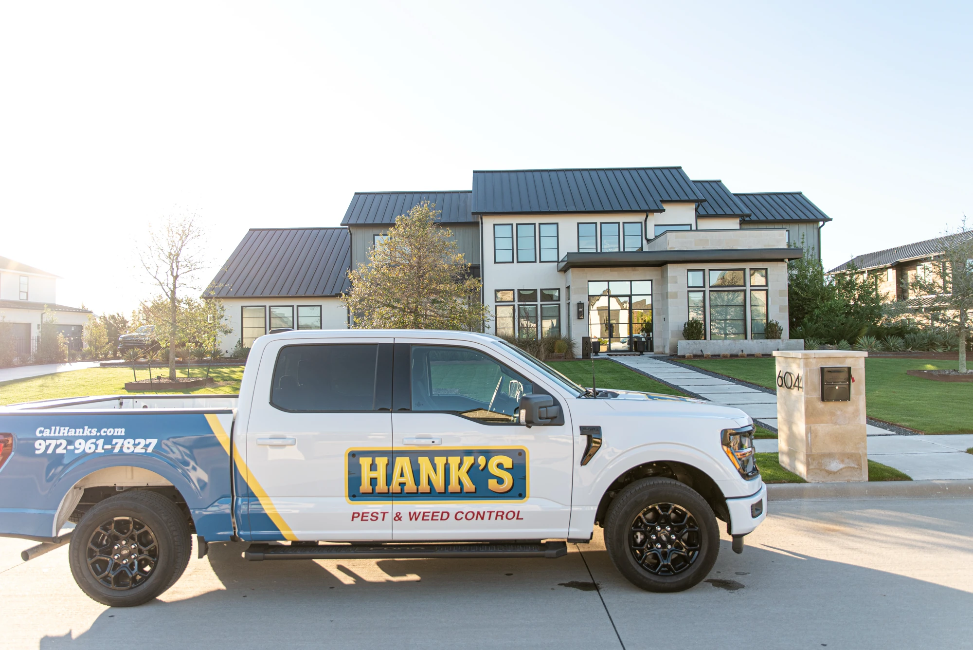 Hank's Pest and Weed truck parked in front of a North Texas home