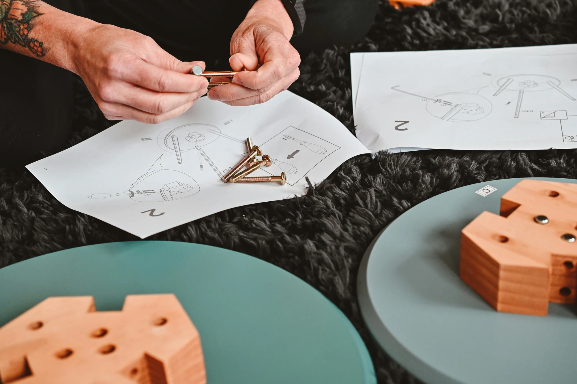Hands sorting hardware while assembling flat-pack furniture