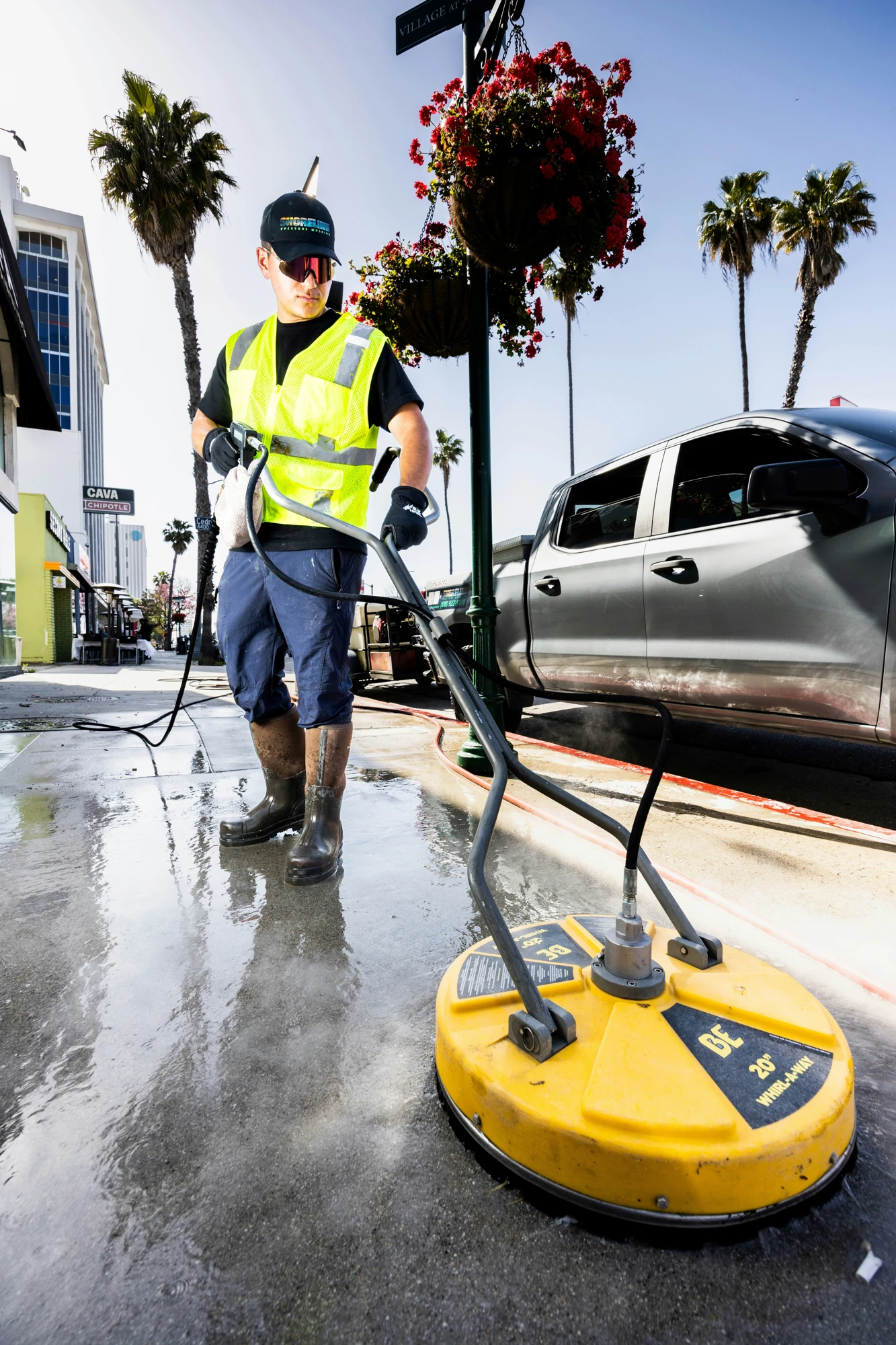 Professional power washing a paved sidewalk