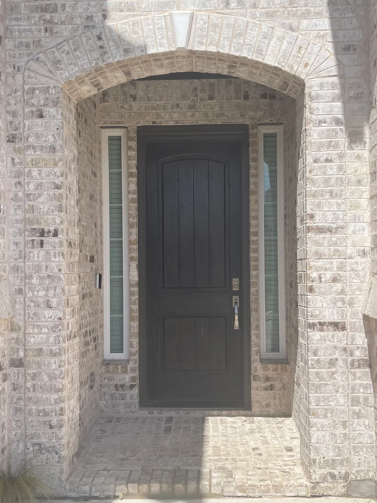 Dark front door with sidelights set in a stone entryway