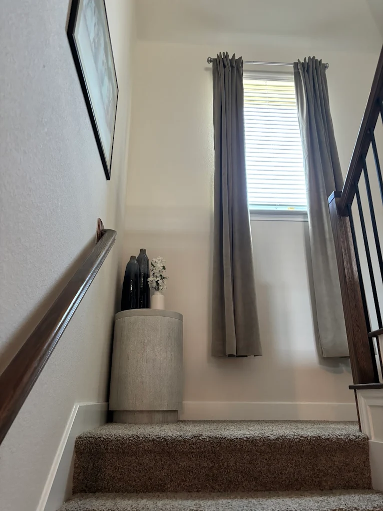 unnamed (33) Stairwell window framed by gray curtains