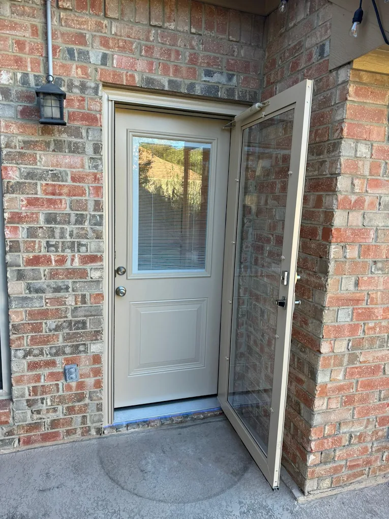 Gray exterior door installed in a brick wall