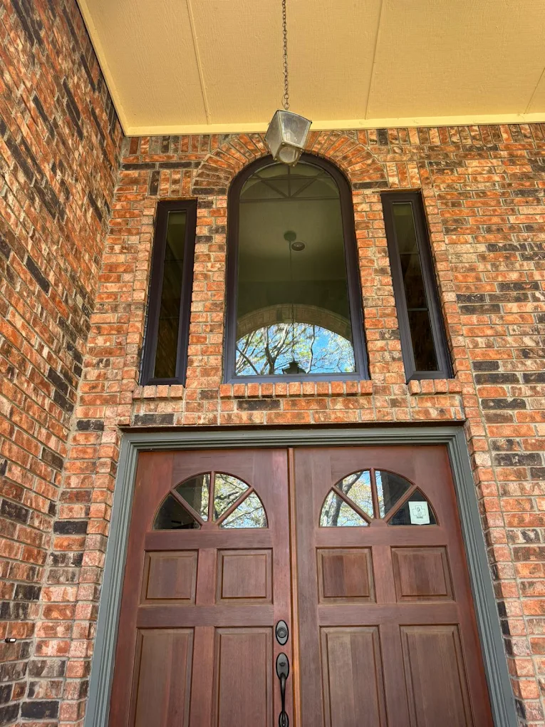 unnamed (54) Arched wood front door beneath a tall brick entryway