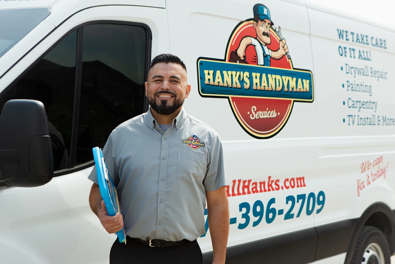 Hank's technician holding a tablet beside a branded service van