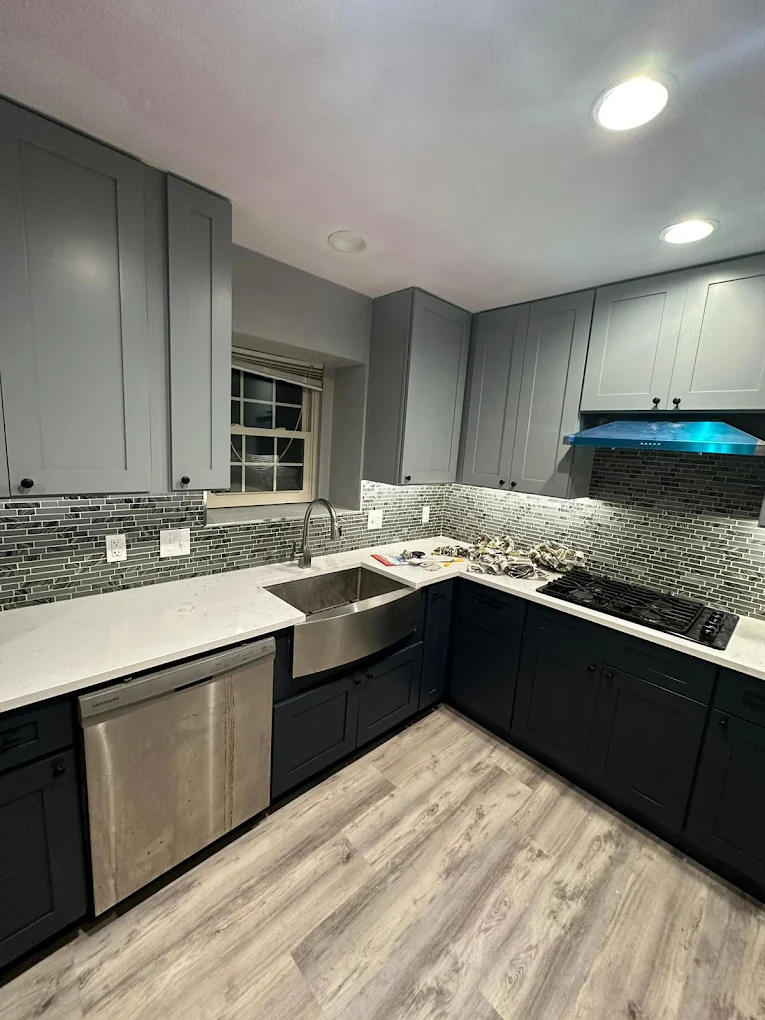 Remodeled kitchen with dark cabinets and wood-look flooring
