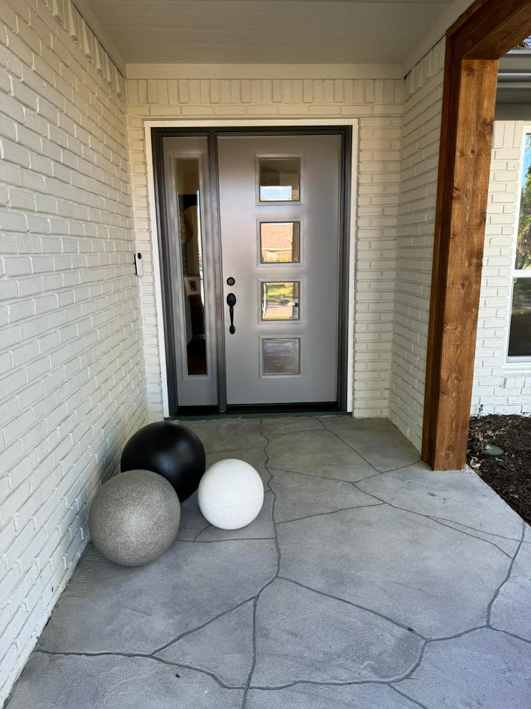 Updated covered entryway with a modern front door and tile floor