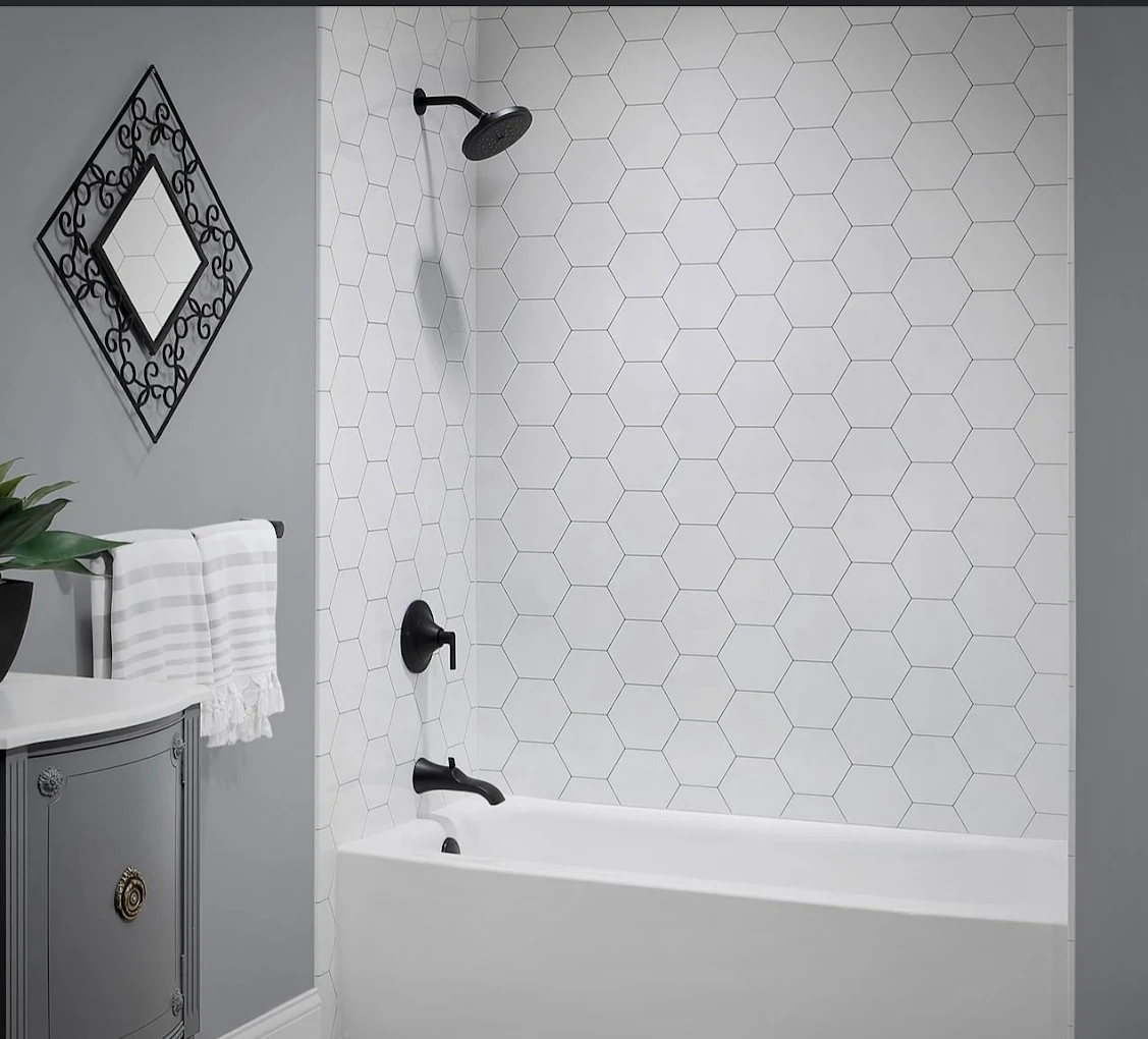 Remodeled bathroom with a tiled tub surround and hexagon wall tile